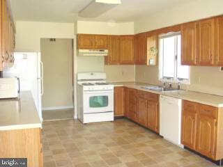 35205 Poplar Neck Road Pittsville, MD 21850 - Photo 5 of 12 a kitchen with a refrigerator sink and cabinets