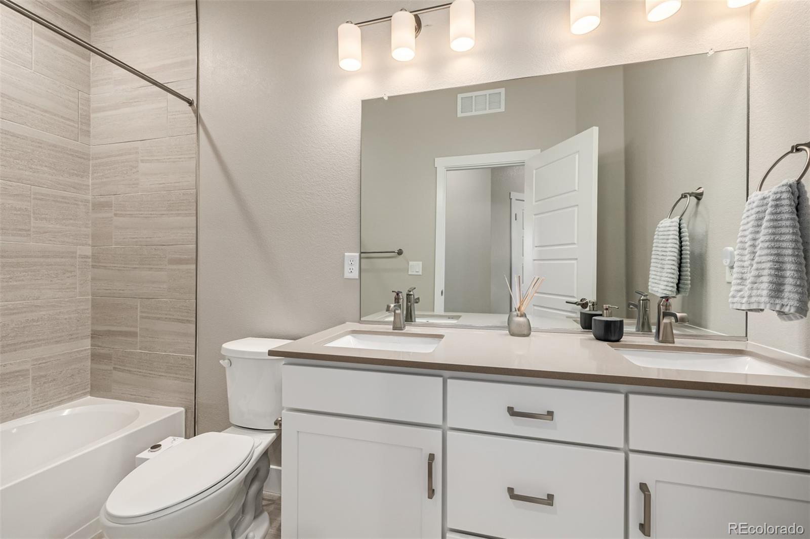 1575 West 68th Avenue Denver, CO 80221 - Photo 26 of 39 a bathroom with a granite countertop sink toilet mirror and bathtub