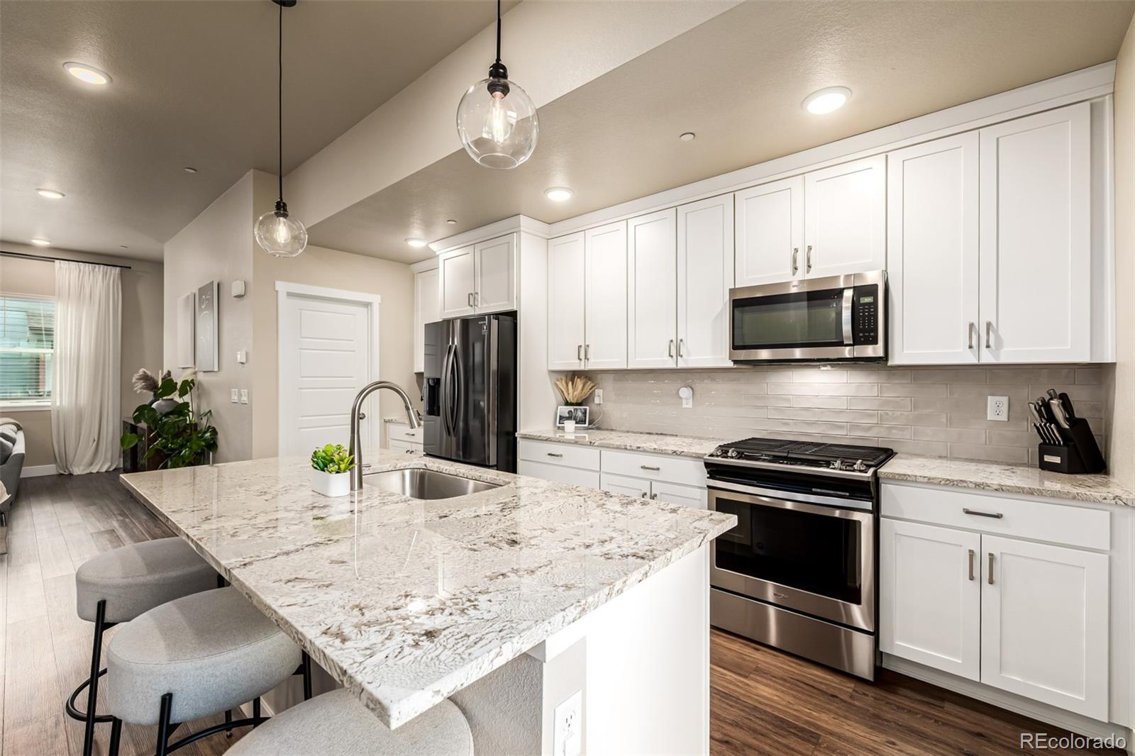 1575 West 68th Avenue Denver, CO 80221 - Photo 10 of 39 a kitchen with kitchen island granite countertop a sink appliances and cabinets