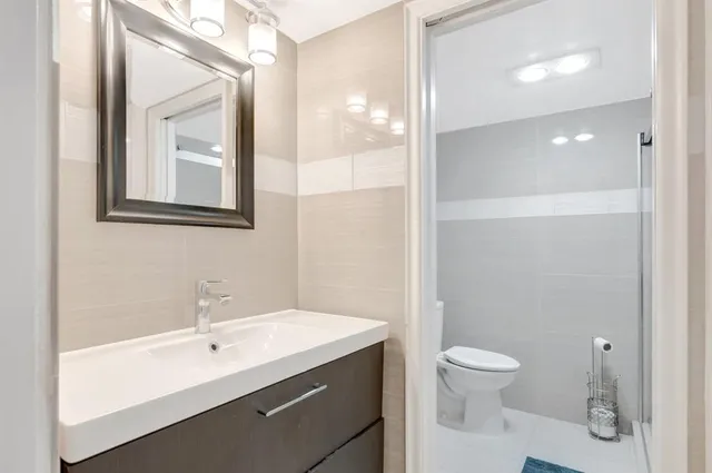 a bathroom with a toilet sink and mirror