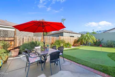 a view of patio with chairs and table under an umbrella