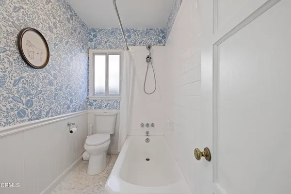 a bathroom with a granite countertop sink a toilet and a shower