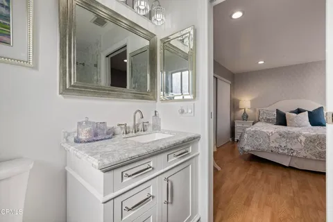 a en suite bathroom with a granite countertop sink and a mirror