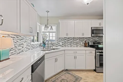 a kitchen with stainless steel appliances granite countertop a sink stove and cabinets