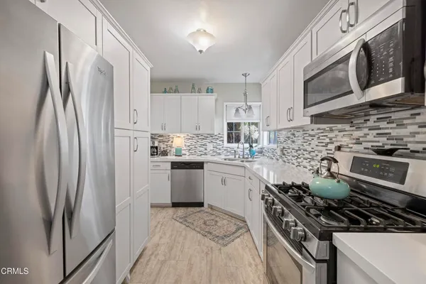 a kitchen with stainless steel appliances a stove a sink and a refrigerator