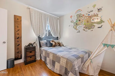 a bedroom with a bed and a flat tv screen on the wall