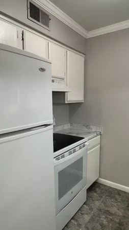 a kitchen with white cabinets and white appliances