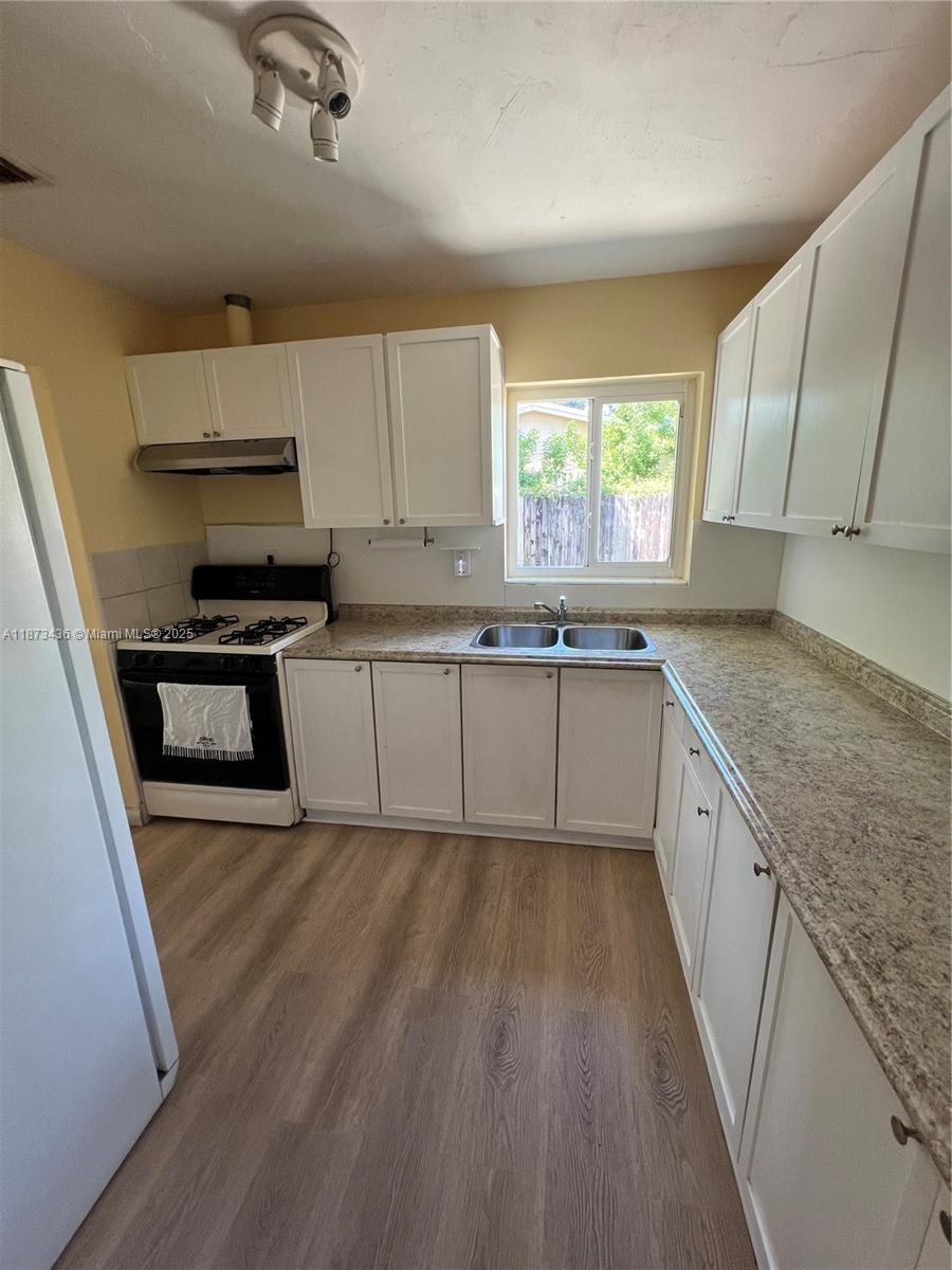 10315 Southwest 152nd Terrace Miami, FL 33157 - Photo 3 of 12 a kitchen with a sink a window stainless steel appliances and cabinets