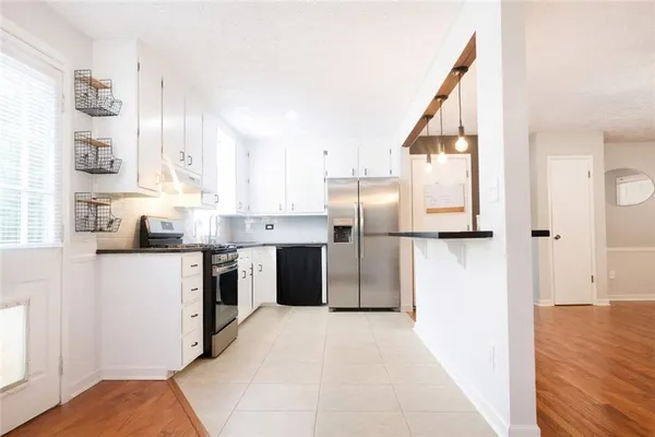 a kitchen with stainless steel appliances granite countertop a refrigerator a sink and a stove