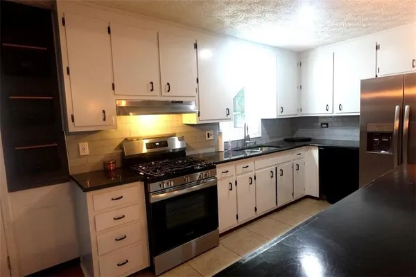 a kitchen with granite countertop cabinets and steel stainless steel appliances