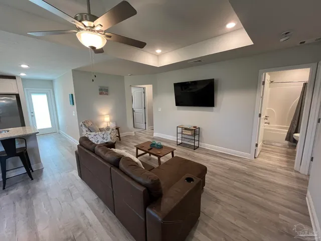 a living room with furniture flat screen tv and wooden floor