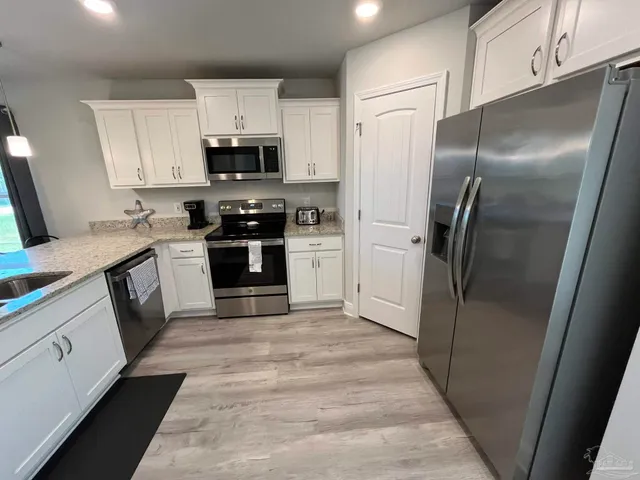 a kitchen with stainless steel appliances granite countertop a refrigerator stove and sink