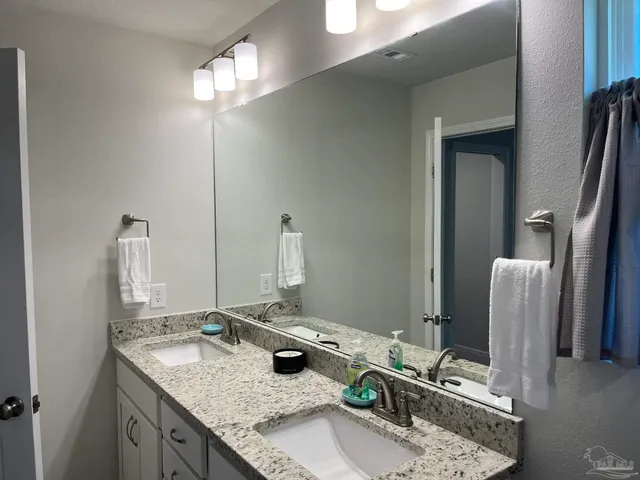 a bathroom with a granite countertop sink and a mirror