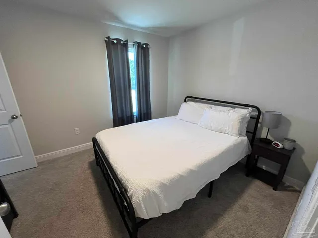 a large bed sitting in a bedroom next to a window