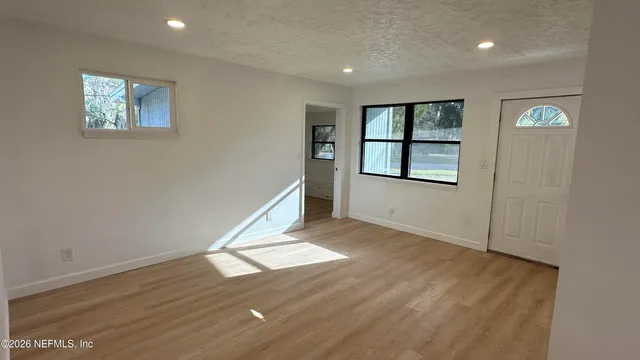 a view of an empty room with wooden floor