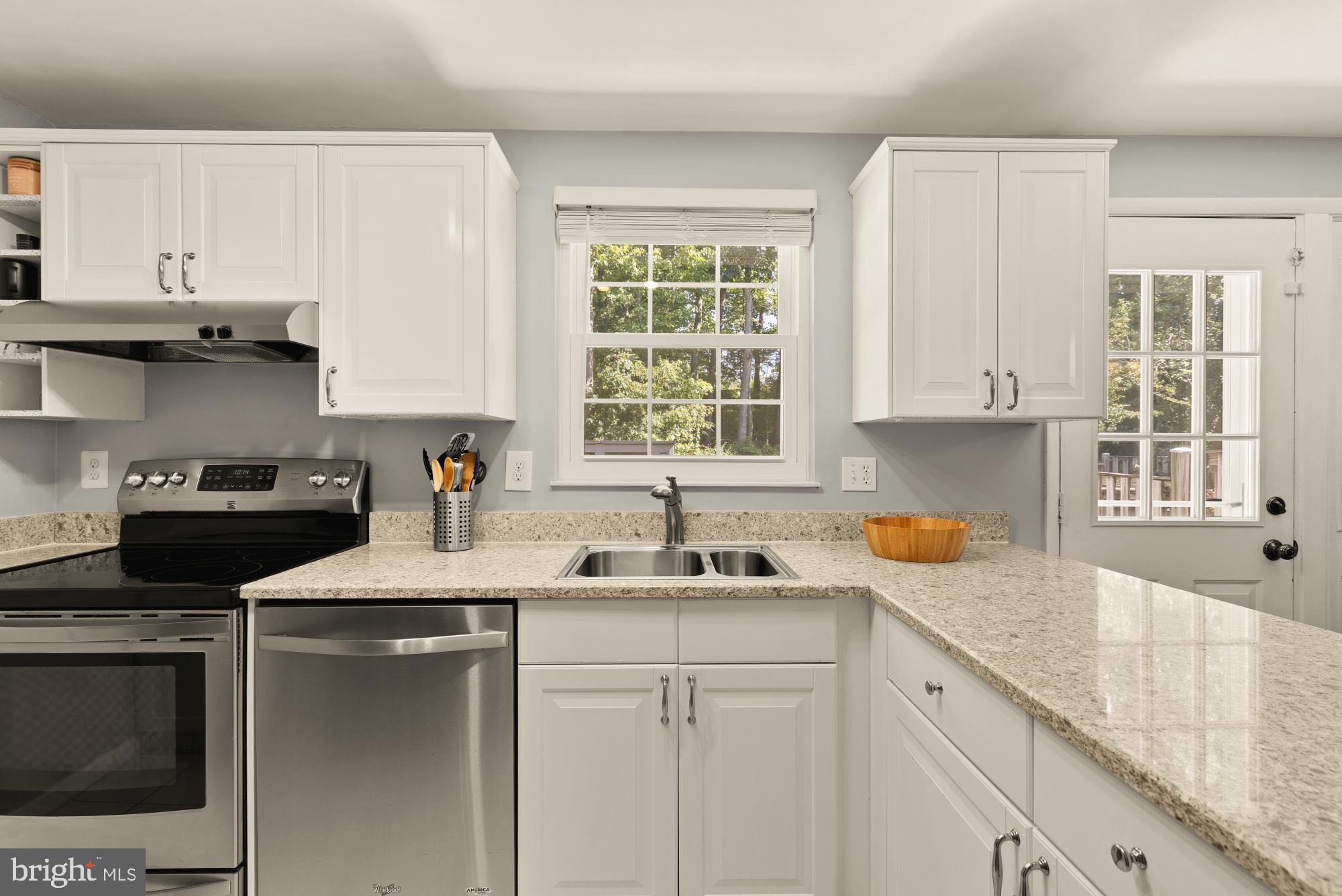 8100 Loving Forest Court Springfield, VA 22153 - Photo 13 of 33 a kitchen with stainless steel appliances granite countertop white cabinets a stove a sink and a microwave