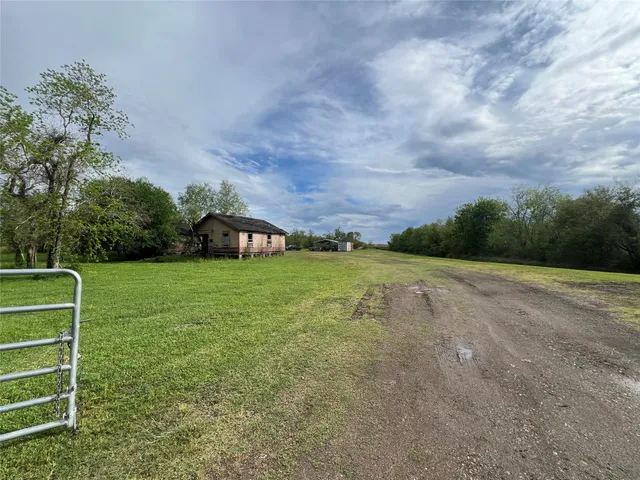 a view of a green field with wooden fence
