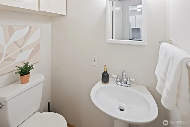 a bathroom with a sink a toilet and a mirror