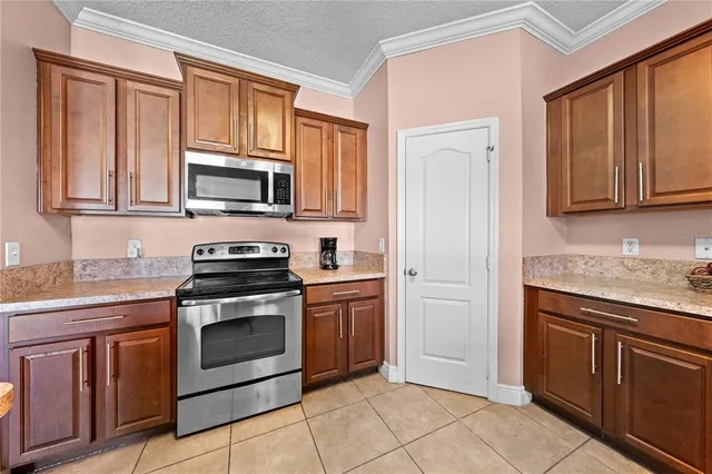 a kitchen with granite countertop a stove top oven microwave and cabinets
