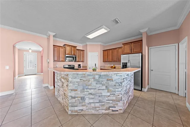 a kitchen with stainless steel appliances kitchen island granite countertop a granite counter tops and a view of living room