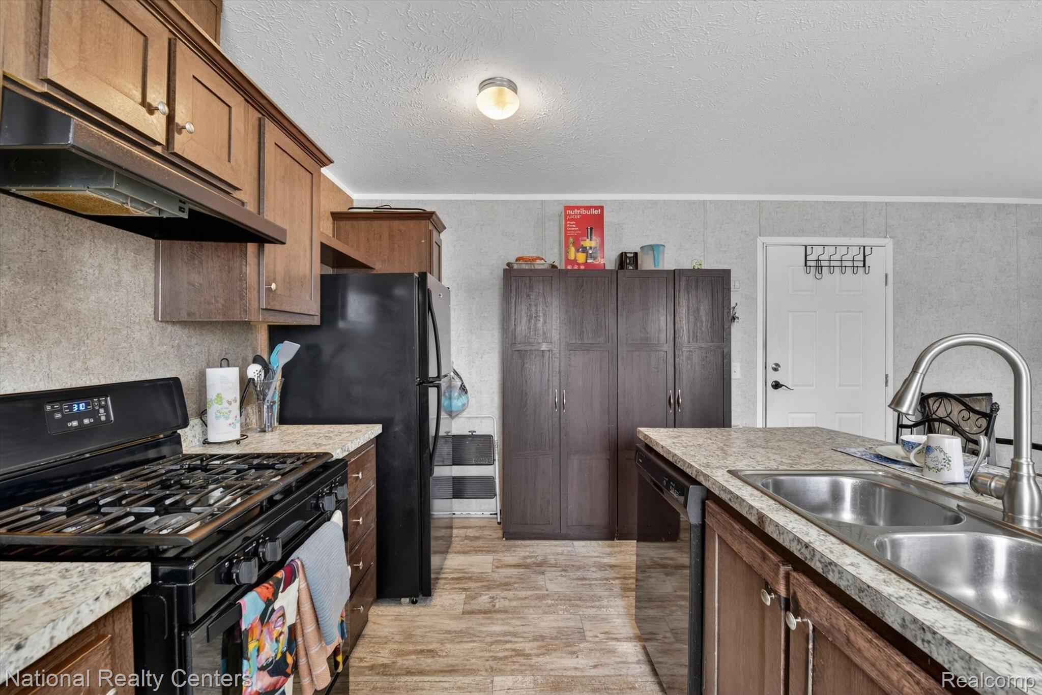 2735 South Wagner Road, Unit 103 Ann Arbor, MI 48103 - Photo 7 of 20 Kitchen with black appliances, light countertops, and a textured ceiling