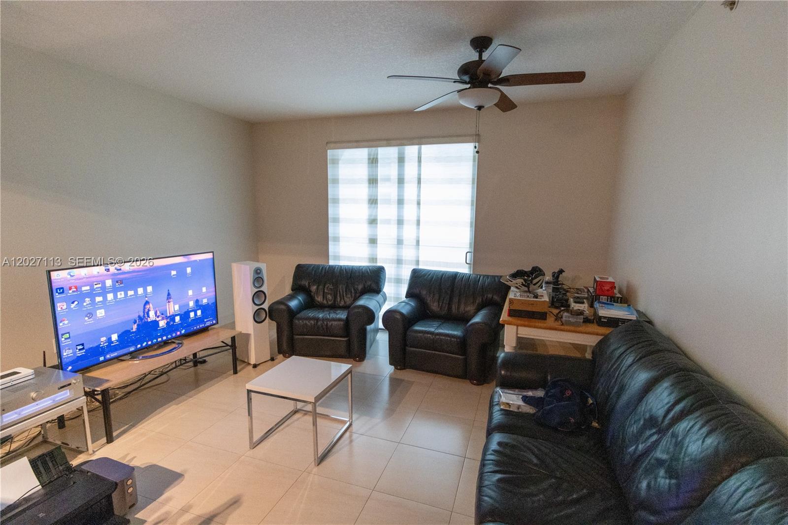 7275 Southwest 90th Way, Unit 213 Miami, FL 33156 - Photo 9 of 31 a living room with furniture and a flat screen tv