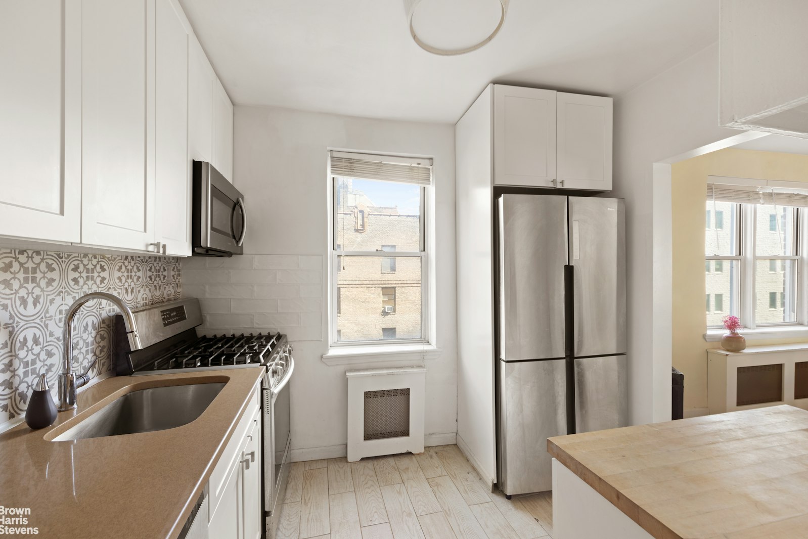 800 Grand Concourse, Unit 3LN Bronx, NY 10451 - Photo 4 of 9 a kitchen with a refrigerator sink and white cabinets