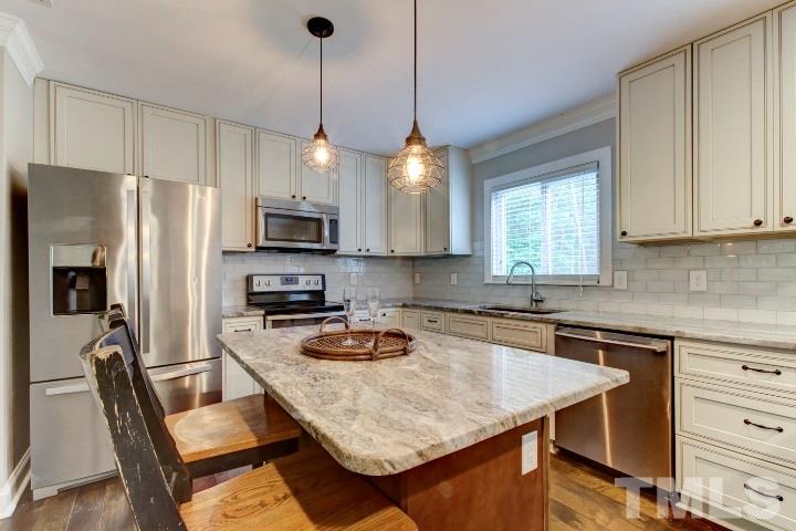 521 Ranch Farm Road Raleigh, NC 27603 - Photo 13 of 30 a kitchen with refrigerator a stove a sink cabinets and a dining table