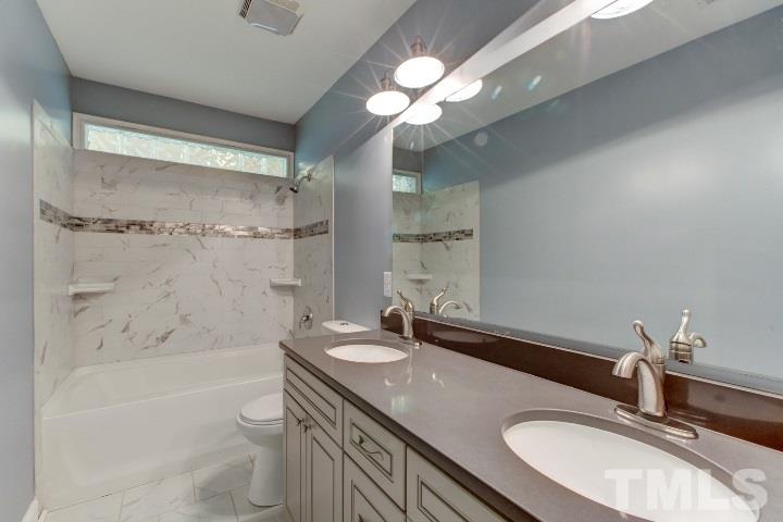 521 Ranch Farm Road Raleigh, NC 27603 - Photo 24 of 30 a bathroom with a granite countertop sink a toilet a mirror and shower