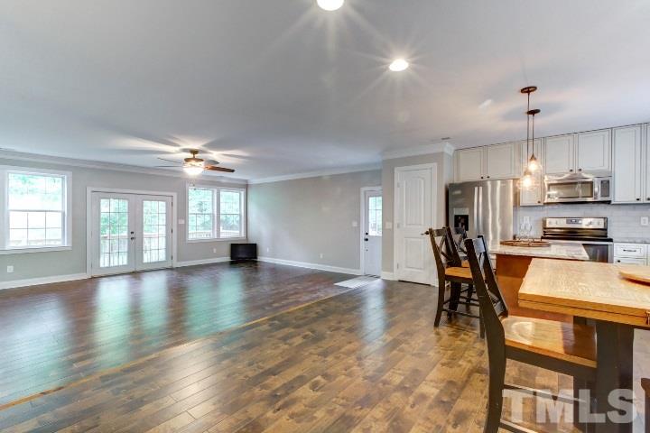 521 Ranch Farm Road Raleigh, NC 27603 - Photo 6 of 30 an open kitchen with granite countertop kitchen island wooden floor center island and stainless steel appliances