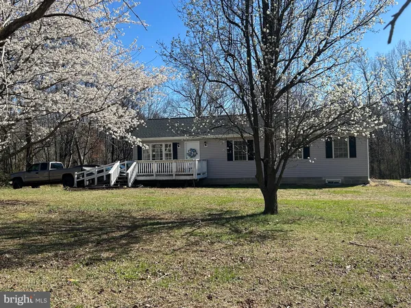 a front view of a house with a yard and trees