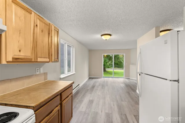 a view of a kitchen with wooden floor electronic appliances and stairs