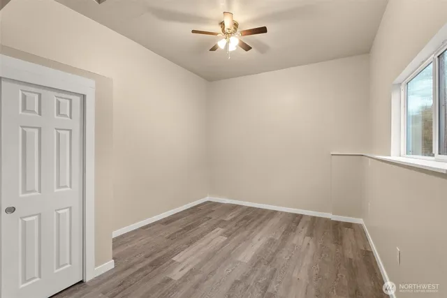 a view of a white house with a big yard and large trees