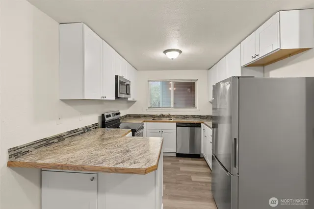 a view of a hallway with wooden floor and closet