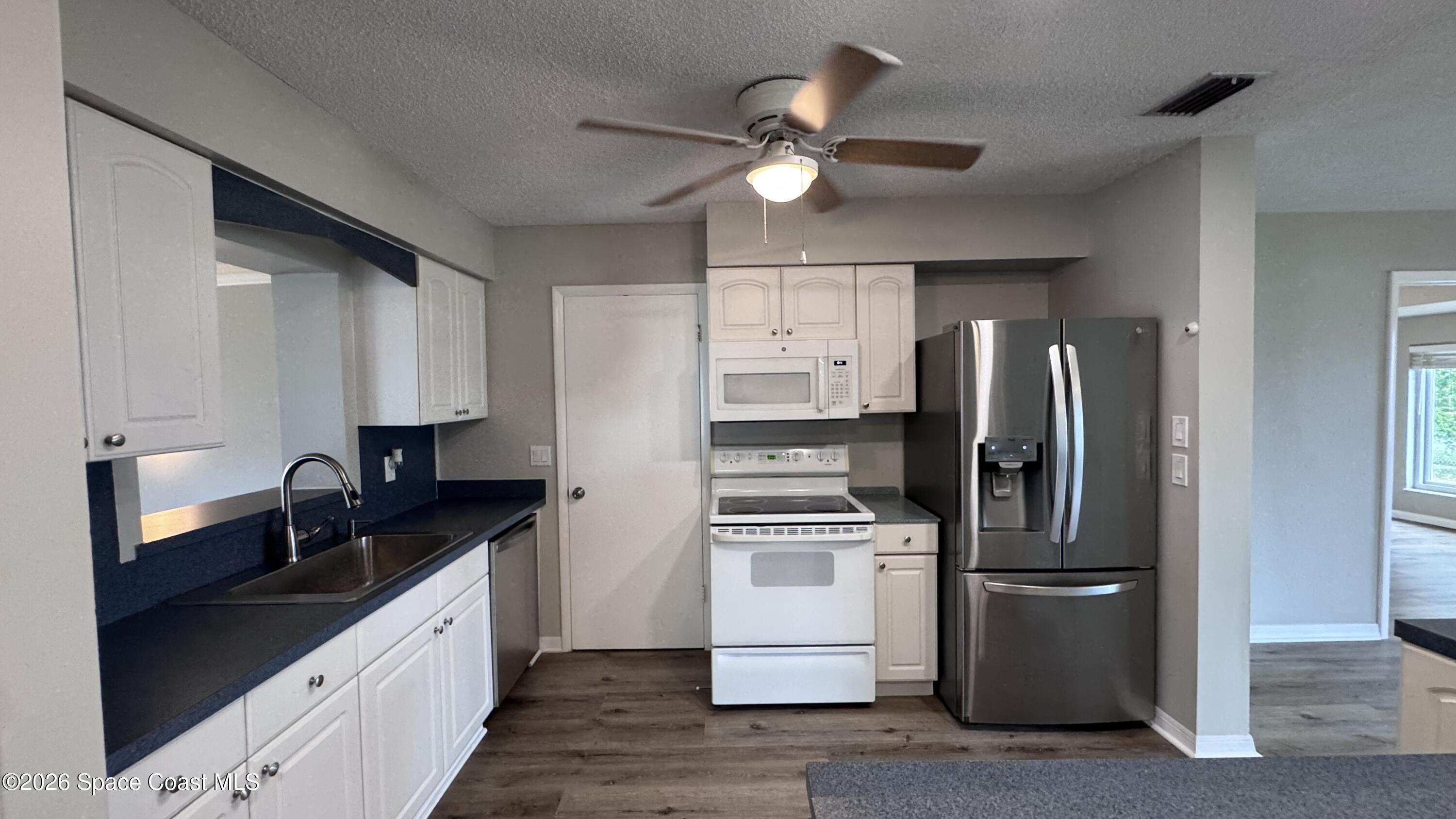 2137 Laden Road Melbourne, FL 32935 - Photo 3 of 23 a kitchen with stainless steel appliances a refrigerator sink and microwave