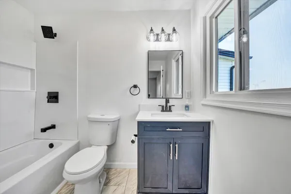 a bathroom with a toilet a sink and mirror