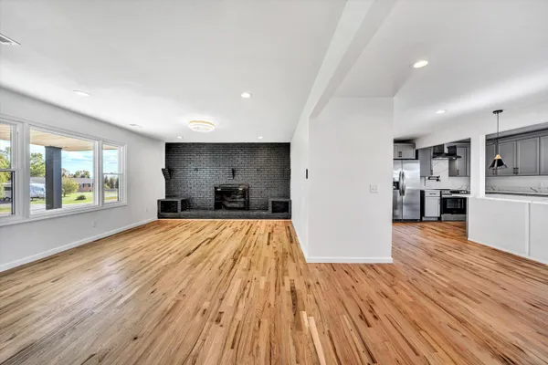 a view of empty room with wooden floor and windows