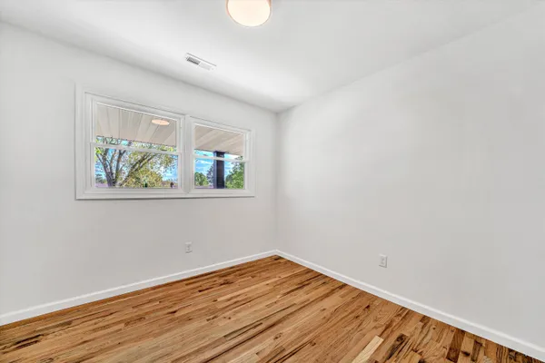 a view of empty room with wooden floor