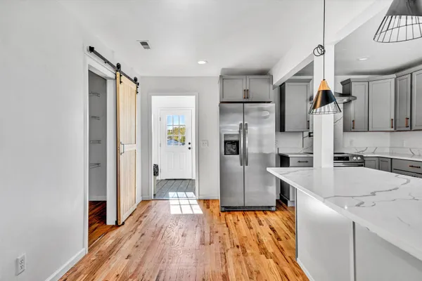 a kitchen with a sink a refrigerator and wooden floor