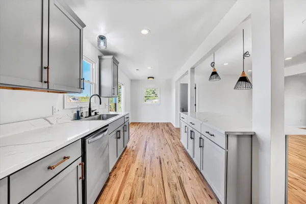 a kitchen with granite countertop a sink and wooden cabinets