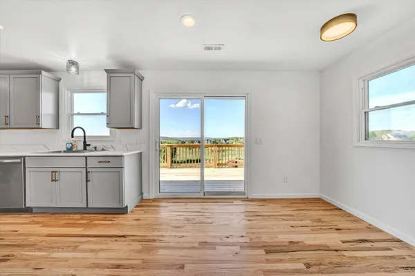 a view of a kitchen with a sink hardwood floor and a window
