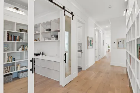 a view of hallway with cabinets and wooden floor