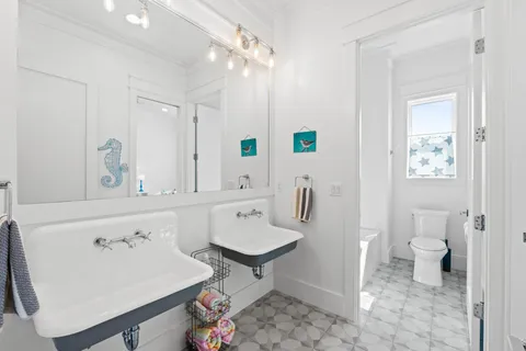 a spacious bathroom with a sink a toilet and a mirror