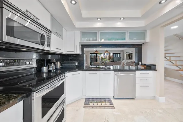 a kitchen with stainless steel appliances granite countertop a stove and cabinets