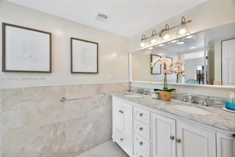 a bathroom with double sink and a mirror