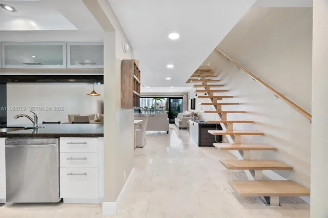 a kitchen with white cabinets and sink