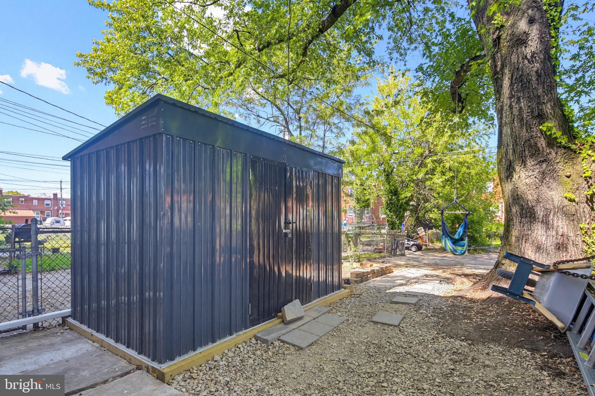 4028 Raymonn Avenue Baltimore, MD 21213 - Photo 27 of 36 Charming backyard shed in lush greenery.
