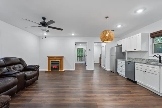 a backyard of a house with large trees and wooden fence