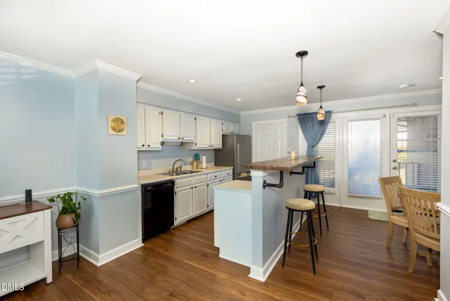 a kitchen that has a table chairs and a wooden floor