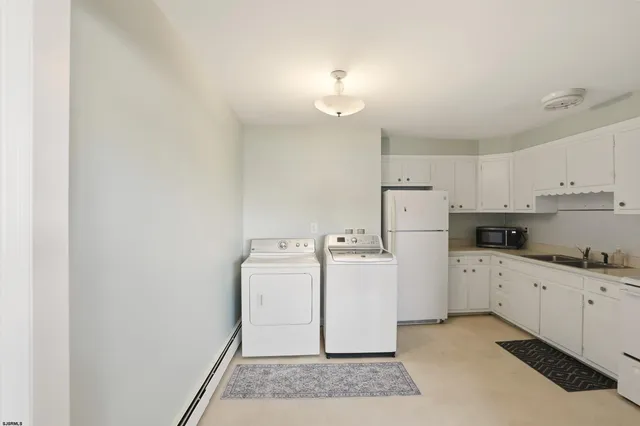 a kitchen with white cabinets and white appliances